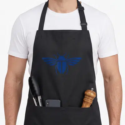 Tablier de cuisine noir avec un scarabée bleu aux ailes stylisées et symétriques imprimé au centre.