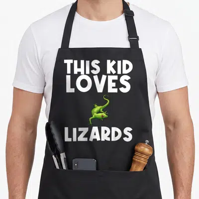 Tablier de cuisine noir avec texte blanc This Kid Loves Lizards et illustration de lézard vert aux yeux rouges.