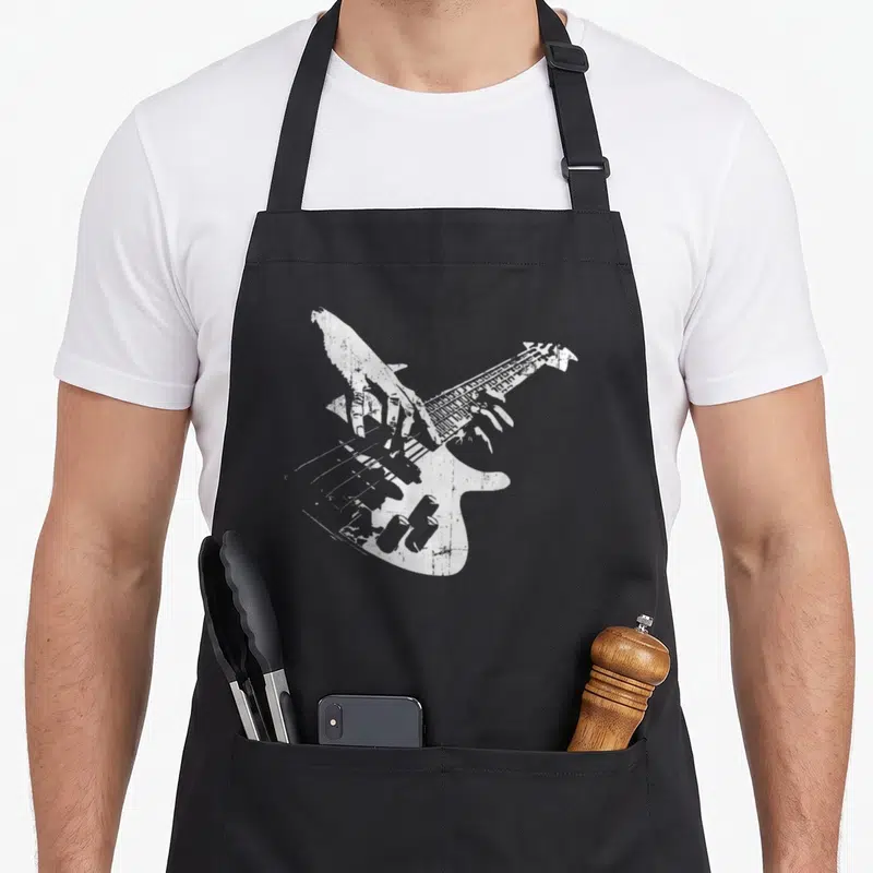 Tablier de cuisine noir avec illustration blanche d'une main jouant d'une guitare basse au style vintage et égréné.