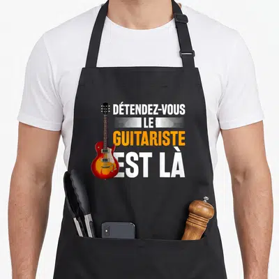 Tablier de cuisine noir avec illustration de guitare électrique rouge et texte blanc orange Détendez-vous le guitariste est là