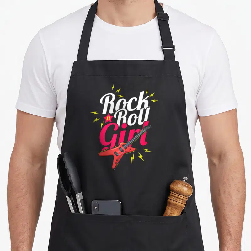 Tablier de cuisine noir avec inscription Rock n Roll Girl et guitare électrique rouge stylisée entourée d'éclairs jaunes.