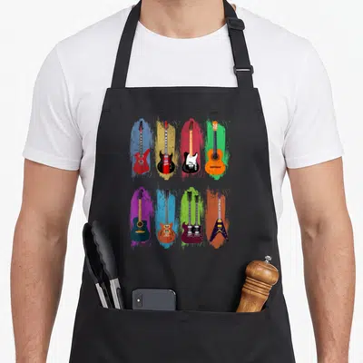 Tablier de cuisine noir avec huit guitares électriques et acoustiques aux couleurs vives disposées en grille.