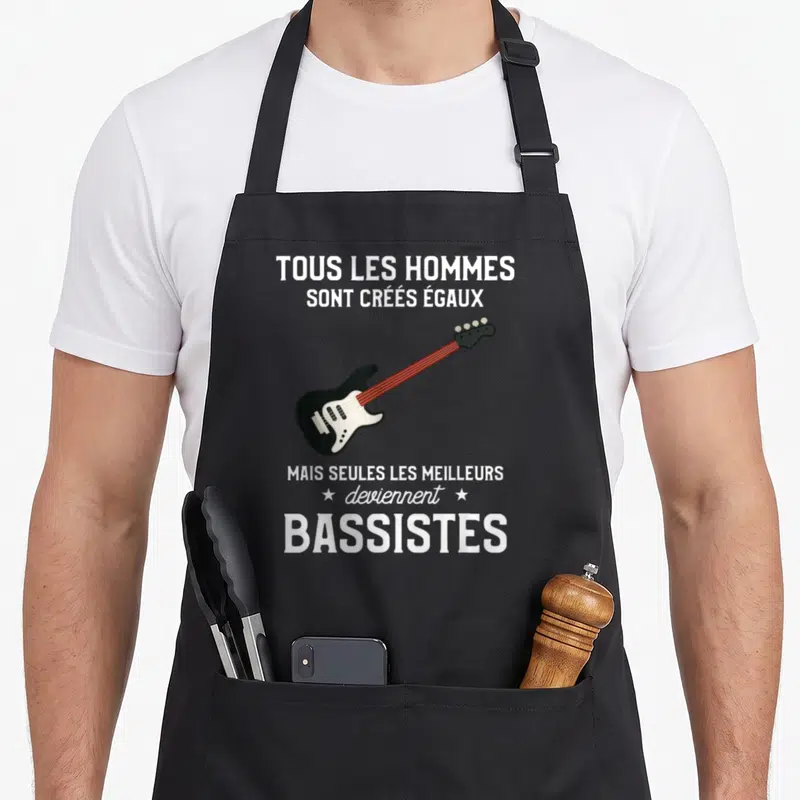 Tablier de cuisine noir avec illustration d'une basse électrique noire et blanche sur fond gris uni.