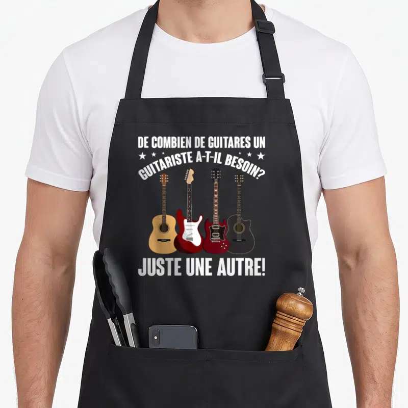 Tablier de cuisine noir avec quatre guitares illustrées et une question humoristique sur le nombre d'instruments nécessaires.