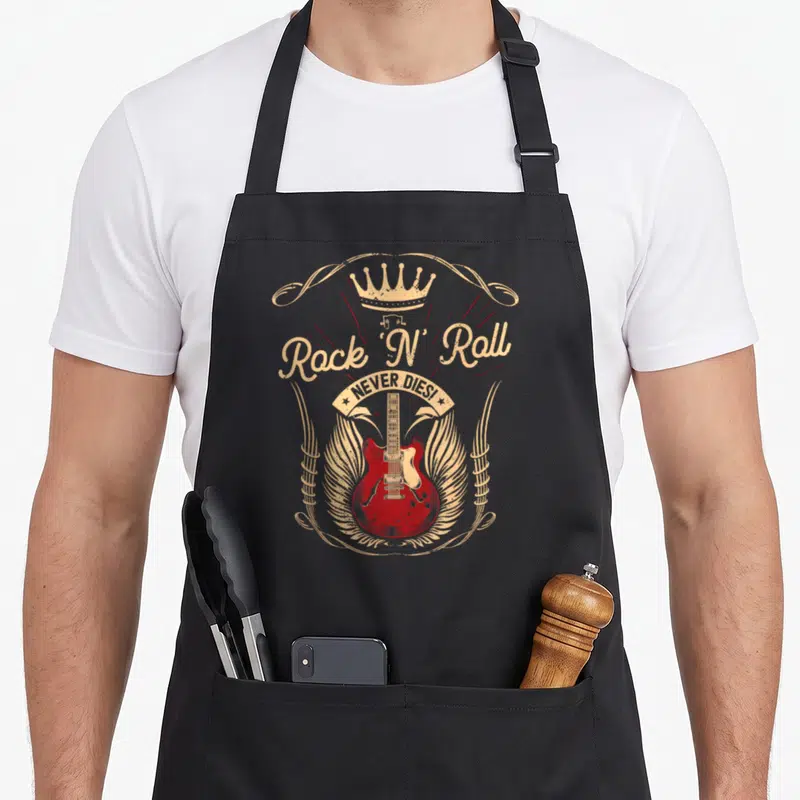 Tablier de cuisine noir avec illustration basse rouge ailée, couronne et texte Rock N Roll Never Dies en style vintage.