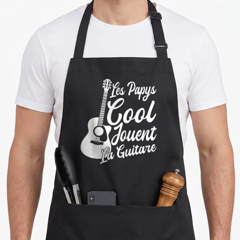 Tablier de cuisine noir avec inscription Les Papys Cool Jouent La Guitare et silhouette d'accordéon blanc.
