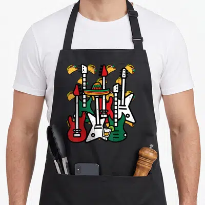 Tablier de cuisine noir avec des guitares, un sombrero et des tacos imprimés en couleurs vives.