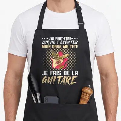 Tablier de cuisine noir avec illustration vintage d'une main jouant d'une basse rose et texte humoristique sur la musique.