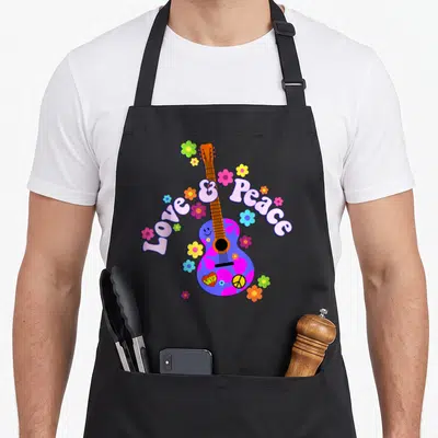 Tablier de cuisine noir avec une guitare rose et bleue Love & Peace entourée de fleurs multicolores et d'un signe de paix.
