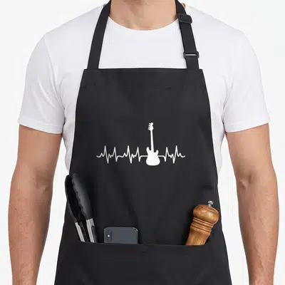 Tablier de cuisine noir avec une silhouette de guitare électrique blanche intégrée à une ligne de pulsation cardiaque stylisée.