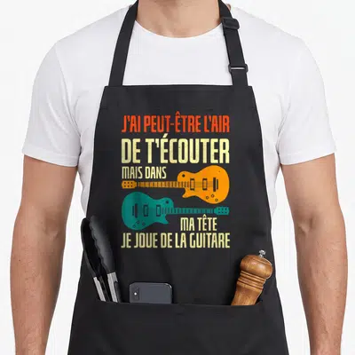 Tablier de cuisine noir avec deux guitares électriques orange et vertes et un texte humoristique sur le fond uni.