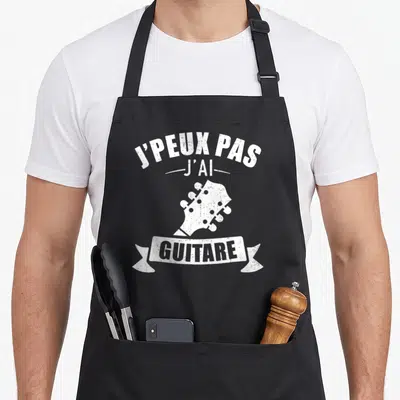 Tablier de cuisine noir avec l'inscription J'peux pas j'ai guitare et une illustration de tête de guitare blanche vintage.