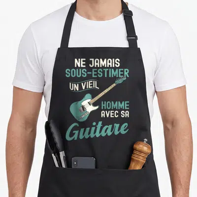 Tablier de cuisine noir avec illustration vintage d'une guitare électrique turquoise et texte humoristique sur fond uni.
