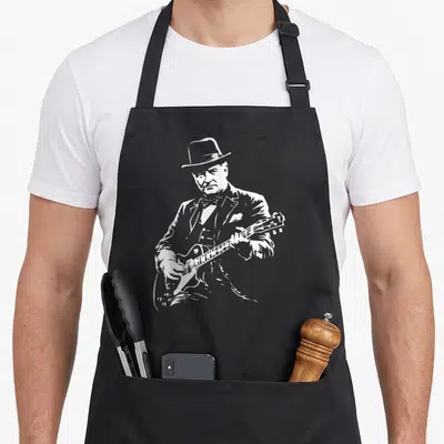 Tablier de cuisine noir avec illustration blanche de Winston Churchill jouant de la guitare électrique en costume.
