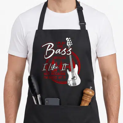 Tablier de cuisine noir avec illustration de basse blanche et texte rouge sur fond circulaire.