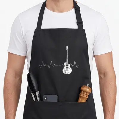 Tablier de cuisine noir avec une illustration blanche d'une ligne d'électrocardiogramme se terminant par une guitare électrique.