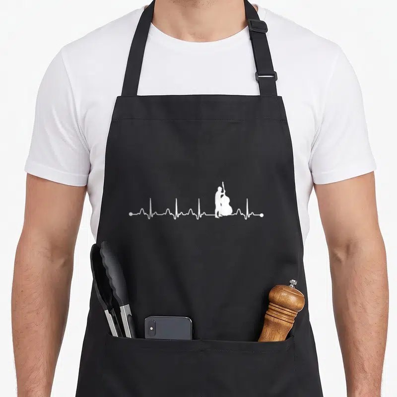 Tablier de cuisine noir avec silhouette blanche d'un musicien jouant de la contrebasse au milieu d'une ligne de rythme cardiaque.