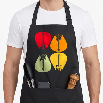 Tablier de cuisine noir avec quatre médiators rouge orange jaune vert clair contenant des illustrations de guitares électriques grises.