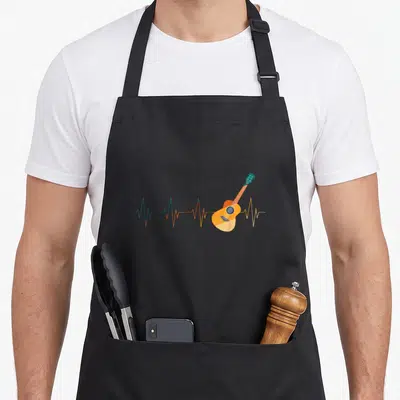 Tablier de cuisine noir avec illustration d'un battement de cœur se transformant en guitare acoustique colorée.