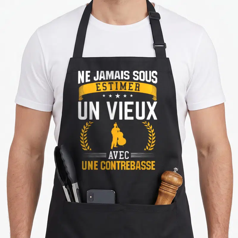 Tablier de cuisine noir avec texte Ne jamais sous-estimer un vieux avec une contrebasse et silhouette orange d'un musicien.