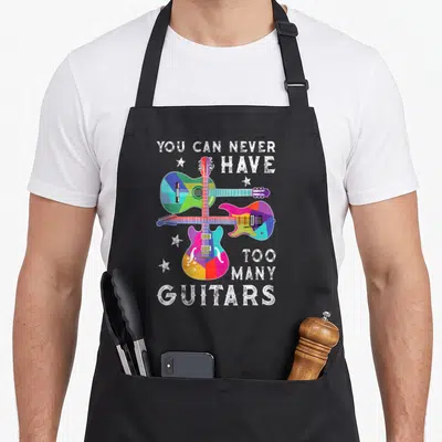 Tablier de cuisine noir avec trois guitares géométriques multicolores et texte blanc You Can Never Have Too Many Guitars.