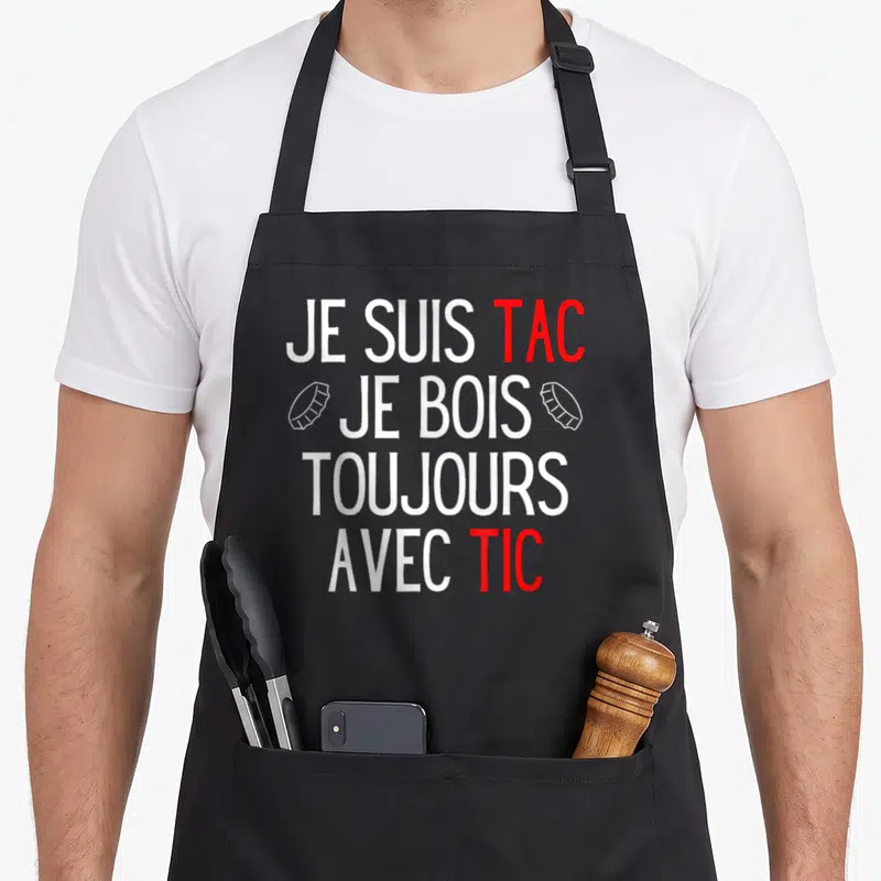 Tablier de cuisine noir avec le texte Je Suis Tac Je Bois Toujours Avec Tic en blanc et rouge.