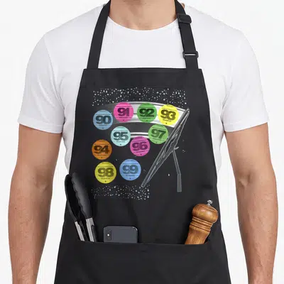 Tablier de cuisine noir avec vignettes colorées années 90 et illustration de balai de vitre sous la pluie.