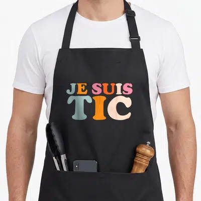 Tablier de cuisine noir avec inscription Je suis TIC en lettres pastel multicolores style rétro.