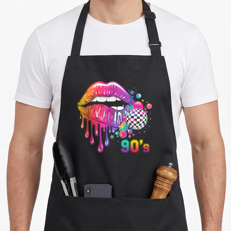 Tablier de cuisine noir avec lèvres colorées qui dégouttent, boule de disco et texte 90s en dégradé.