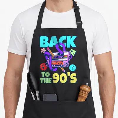 Tablier de cuisine noir avec illustration colorée d'une cassette audio et le texte Back to the 90's en lettres géométriques.