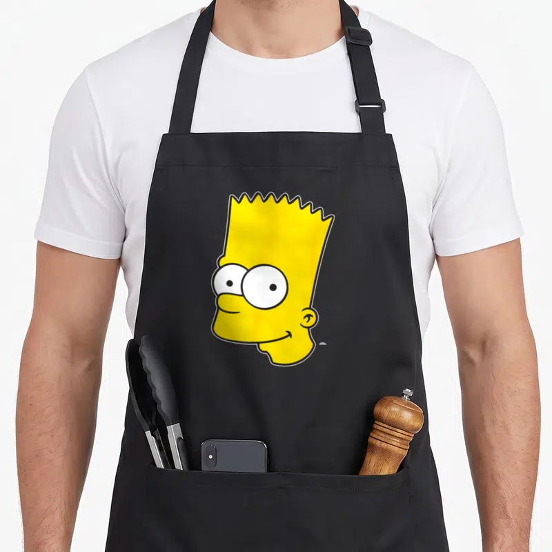 Tablier de cuisine noir avec le visage jaune de Bart Simpson aux grands yeux ronds et sourire espiègle.