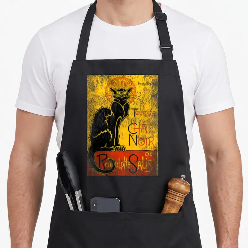 Tablier de cuisine noir avec une illustration vintage représentant un chat noir et le texte Tour du Chat Noir de Rodolphe Salis.