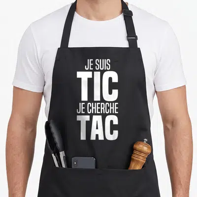 Tablier de cuisine noir avec inscription blanche « Je suis TIC je cherche TAC » en typographie verticale bold.