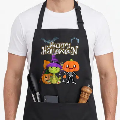 Tablier de cuisine noir avec dinosaure sorcier, citrouille squelette et texte Happy Halloween imprimé en couleur.