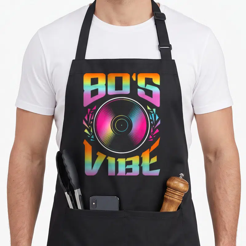 Tablier de cuisine noir avec illustration 80's Vibé et disque vinyl aux couleurs arc-en-ciel.
