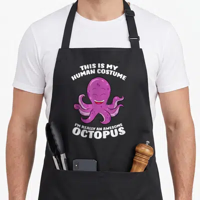 Tablier de cuisine noir avec illustration d'une pieuvre rose souriante et texte blanc en anglais.