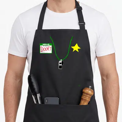 Tablier de cuisine noir avec badge Hello My Name Is Doofy, sifflet vert et étoile jaune.