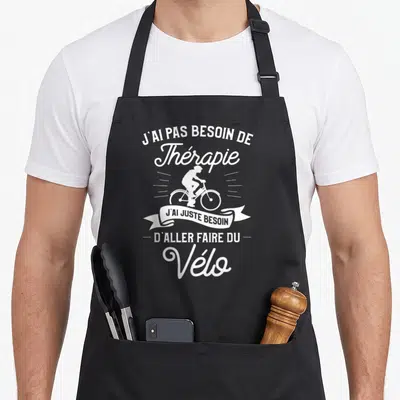 Tablier de cuisine noir avec inscription blanche sur le thème du cyclisme et de l'humour.