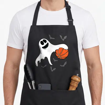 Tablier de cuisine noir avec un fantôme blanc tenant un ballon de basket orange sur fond gris.