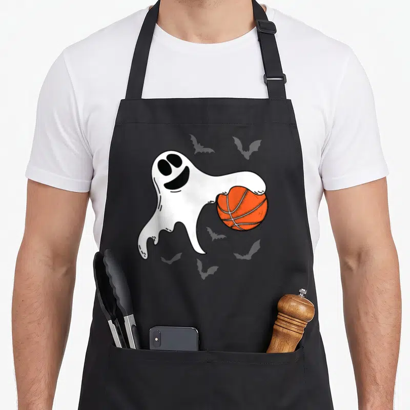 Tablier de cuisine noir avec un fantôme blanc tenant un ballon de basket orange sur fond gris.