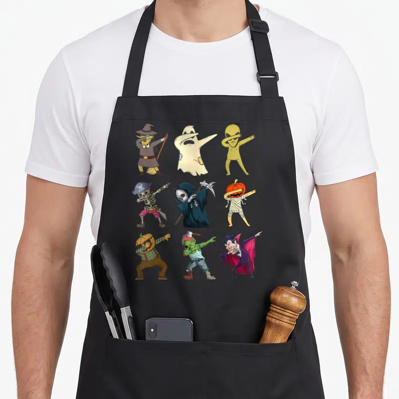 Tablier de cuisine noir avec des monstres en train de faire le dab comme un squelette pirate ou un vampire.