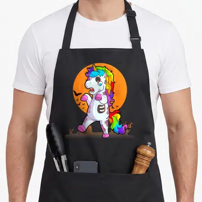 Tablier de cuisine noir avec une licorne zombie aux couleurs vives et un soleil orange en arrière-plan.