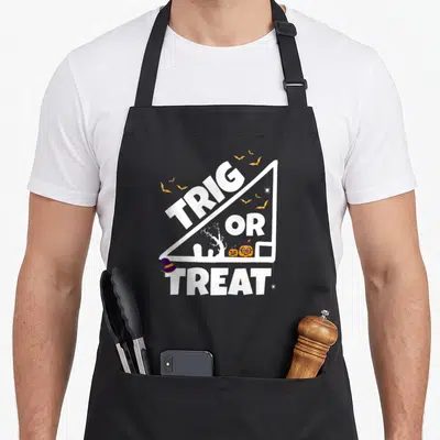 Tablier de cuisine noir avec un triangle blanc contenant le texte Trig or Treat et des citrouilles Halloween.
