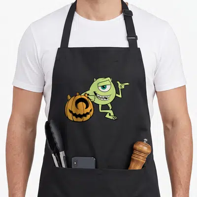 Tablier de cuisine noir avec Mike vert pointant vers une pumpkin orange souriante.