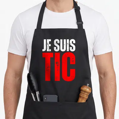 Tablier de cuisine noir avec l'inscription Je Suis Tic en lettres rouges et blanches au style graffiti.
