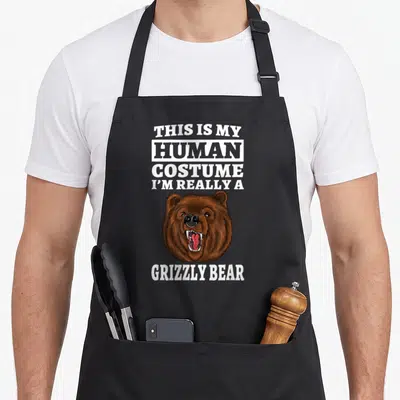 Tablier de cuisine noir avec tête de grizzly rugissant et texte blanc en anglais.