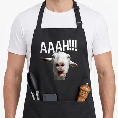 Tablier de cuisine noir avec une chèvre blanche hurlante et le texte AAAH. en lettres blanches au-dessus.