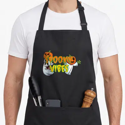 Tablier de cuisine noir avec deux fantômes en cartoon portant des citrouilles et le texte « Spooky Ambiance » au centre.