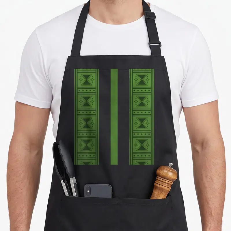 Tablier de cuisine noir avec bandes vertes à motifs géométriques noirs et étoiles stylisées.