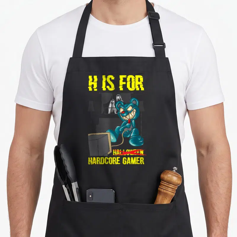 Tablier de cuisine noir avec un ours bleu terrifiant et le texte H Is For Hardcore Gamer imprimé en jaune.